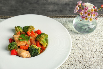 Plate of chicken stir fry with vegetables on table