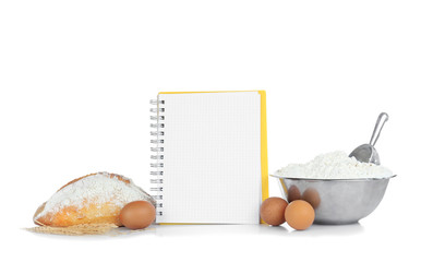 Open recipe book and bread on white background
