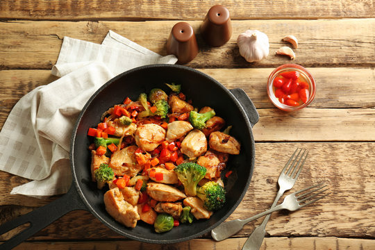 Chicken stir fry with cutlery and spices on table