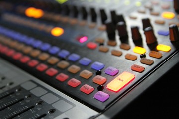 Professional audio operator working on audio mixer knobs during live TV telecast