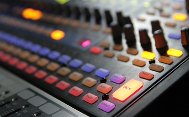 Professional audio operator working on audio mixer knobs during live TV telecast