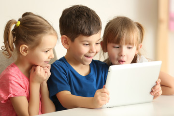 Fototapeta na wymiar Cute kids using digital tablet