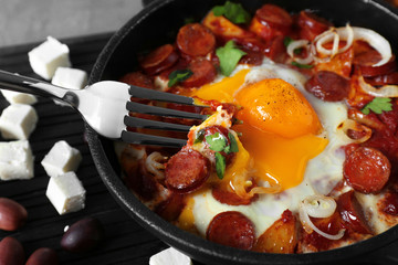Tasty cooked egg with sausages in frying pan