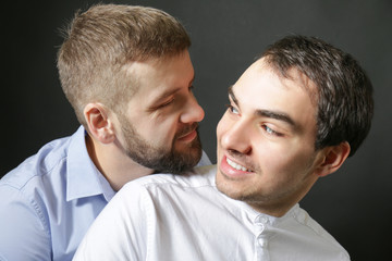Happy gay couple on black background