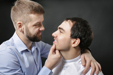 Happy gay couple on black background