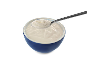 Tasty yogurt in bowl with spoon on white background