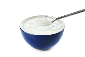 Tasty yogurt in bowl with spoon on white background