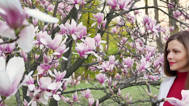 beautiful girl among magnolia pink blossom sping tree flowers