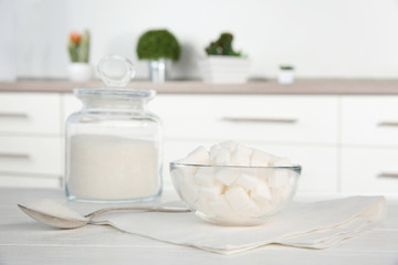Glass bowl with sugar cubes on kitchen table