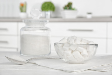 Glass bowl with sugar cubes on kitchen table
