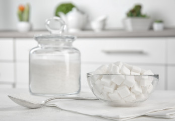 Glass bowl with sugar cubes on kitchen table