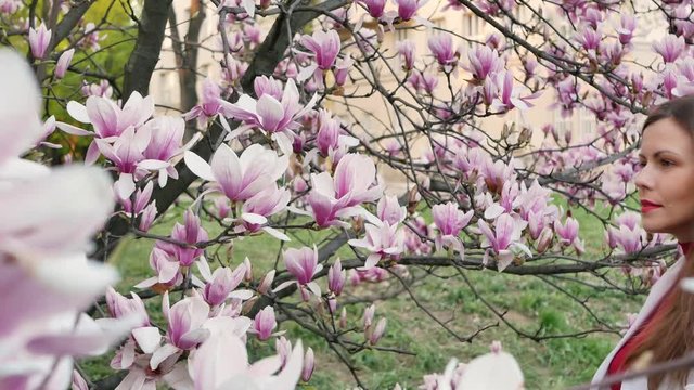 beautiful girl among magnolia pink blossom sping tree flowers