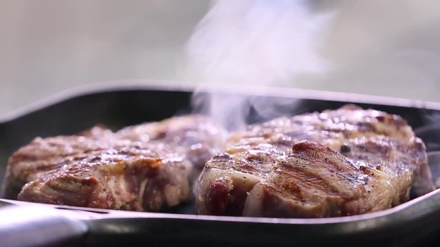 Steaks are fried in a pan.
