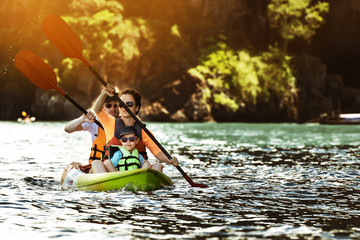 Happy family kayaking at tropical islands © cppzone