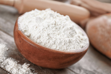 Fototapeta na wymiar Bowl full of white flour on grey wooden table