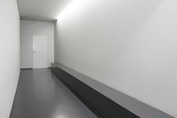 Modern white hallway with door, Minimalist hall with seating, Current public interior corridor, Modern corridor, Open door in  hallway, Cast floor in minimalist interior
