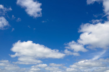 Naklejka na ściany i meble Blue sky with flying clouds over horizon, heaven. White clouds against blue sky.