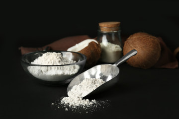 Coconut flour in metal scoop on dark background