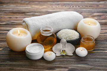 Spa setting with aroma candles, delicious honey and sea salt on wooden table