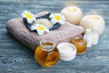 Spa setting with aroma candles and  delicious honey on grey wooden table