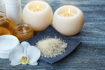 Fototapeta na wymiar Spa setting with aroma candles, delicious honey and sea salt on grey wooden table