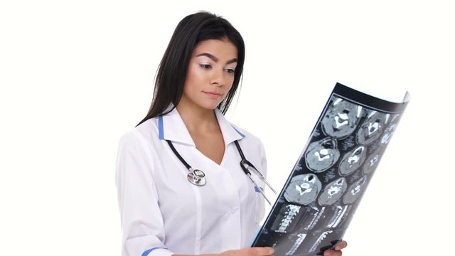 Woman nurse wearing lab white coat inspecting x-ray image and thinking about diagnosis isolated