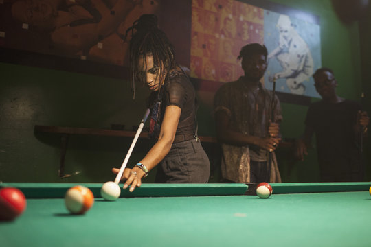 A young woman playing pool.