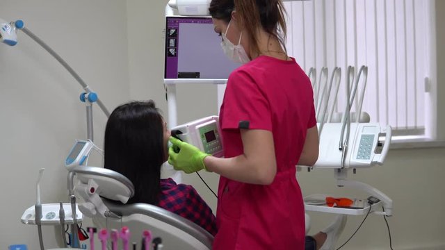 Young female dentist taking jaw x-ray using portable device. Shot in 4k