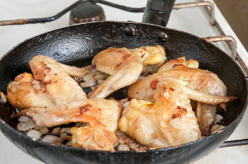 Fried chicken wings in a frying pan