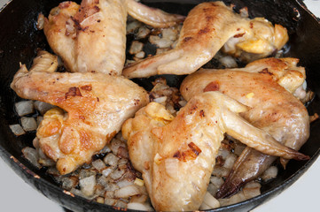 Fried chicken wings in a frying pan