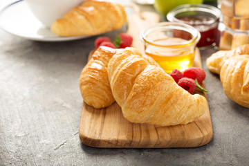 Freshly baked croissants with honey and jam