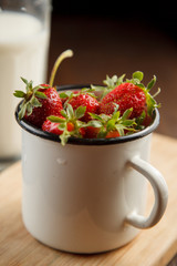 Ripe strawberries in an enamel cup