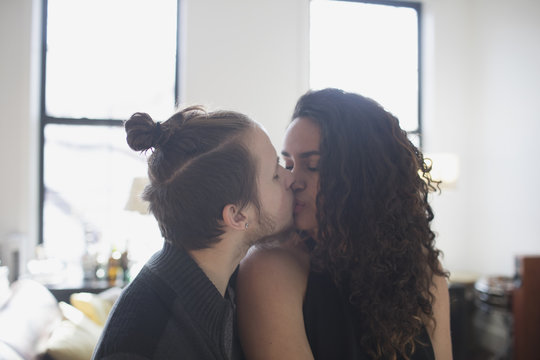 Couple kissing while sitting at home