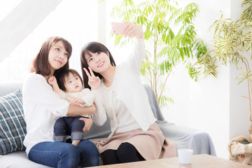 Obraz premium młoda azjatycka rodzina robienia zdjęć w salonie