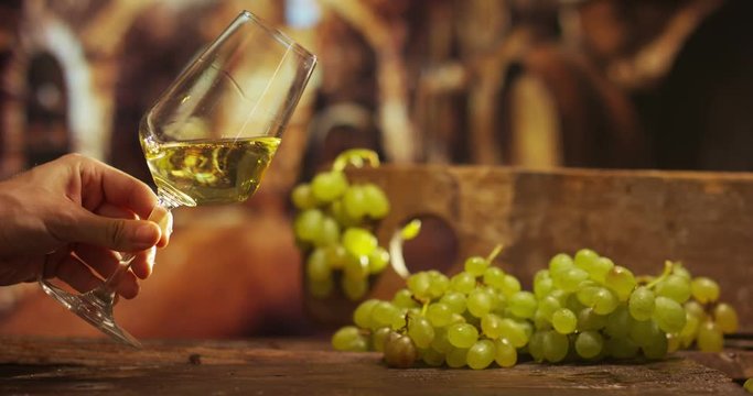 sommelier in vineyard pouring italian white wine in glass in slow motion 