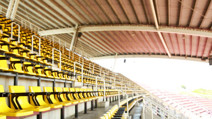 Blur empty yellow seat at Stadium background