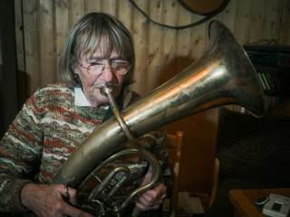 Senior woman is playing on a horn