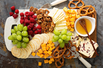 Cheese and snacks platter with honey and fresh fruit