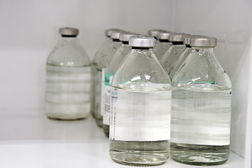 Medical bottles with saline solution, medical locker, supplies of medicines