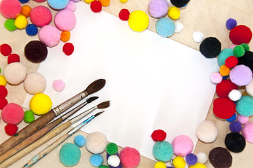 Obraz na płótnie Canvas Frame of colorful pompons for creativity on a wooden background