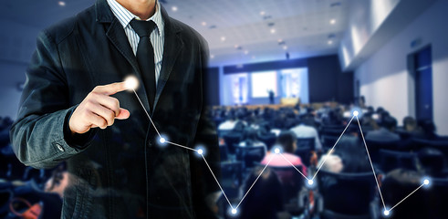 businessman hand touch virtual chart business, conference forum blur background, goal, vision, creativity, teamwork, focus, inspiration, training concept.