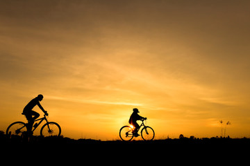 Silhouette of cycling on sunset background