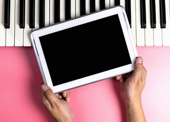Musician is holding blank tablet screen for music application mock up