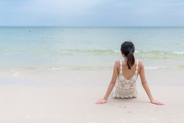 Fototapeta na wymiar Woman relaxing on sand beach