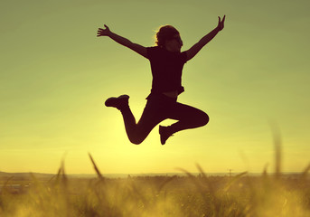 Fototapeta na wymiar Young happiness woman jumping high at sunset.