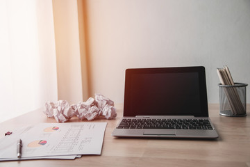 laptop and crumpled paper on working table