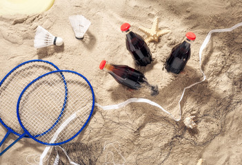 Three bottles of cool drink with items for beach entertainment