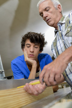Carpenter teaching his teenage son