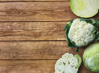 Fresh green garden cabbage and cutted cabbage fnd cauliflower cabbage on rustic wooden background