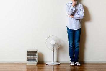 扇風機と電気ストーブ,立っている男性
